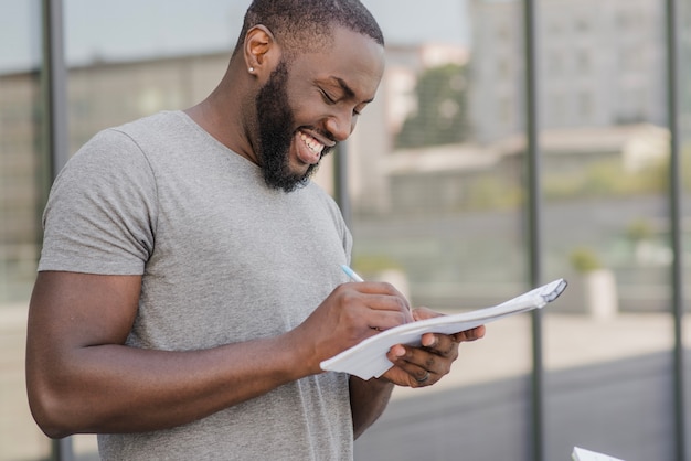 Free photo cheerful african student with papers