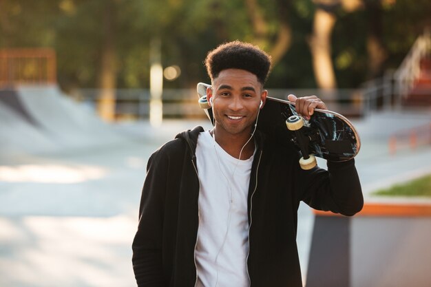 Cheerful african teenager guy with earphones