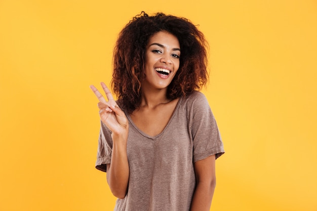 Cheerful african woman showing peace sign