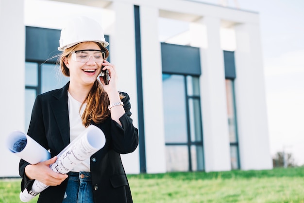 Cheerful architect woman talking on phone