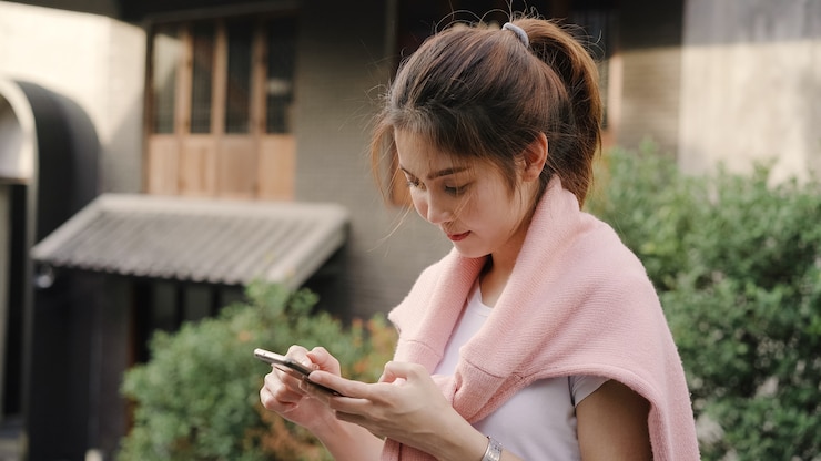 無料Photo 陽気なアジアのバックパッカーブロガーの女性方向とスマートフォンを使用して、中国の北京のチャイナタウンで旅行中にロケーションマップを見ています。
