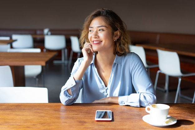 Free photo cheerful asian female entrepreneur sitting at table in cafe