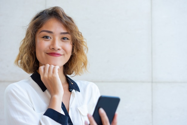 Cheerful Asian phone user networking on phone