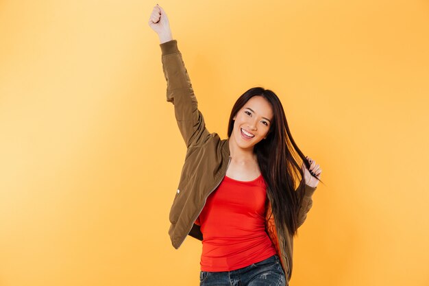 Cheerful asian woman in jacket rejoice and looking at camera