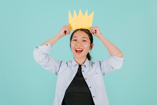 Free photo cheerful asian woman with paper crown