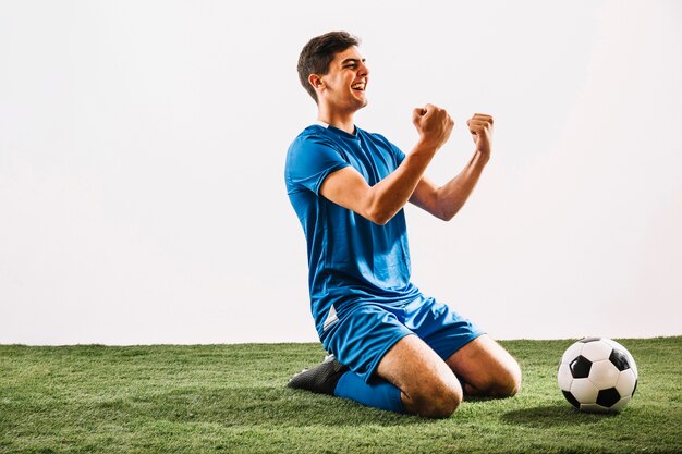 Cheerful athlete celebrating victory on field