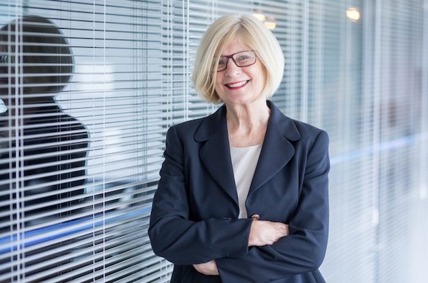 Cheerful attractive businesswoman crossing arms