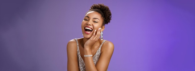 Cheerful attractive happy african american woman in elegant silver light dress laughing flirty giggl