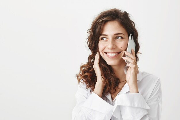 Cheerful attractive woman talking on the phone and smiling