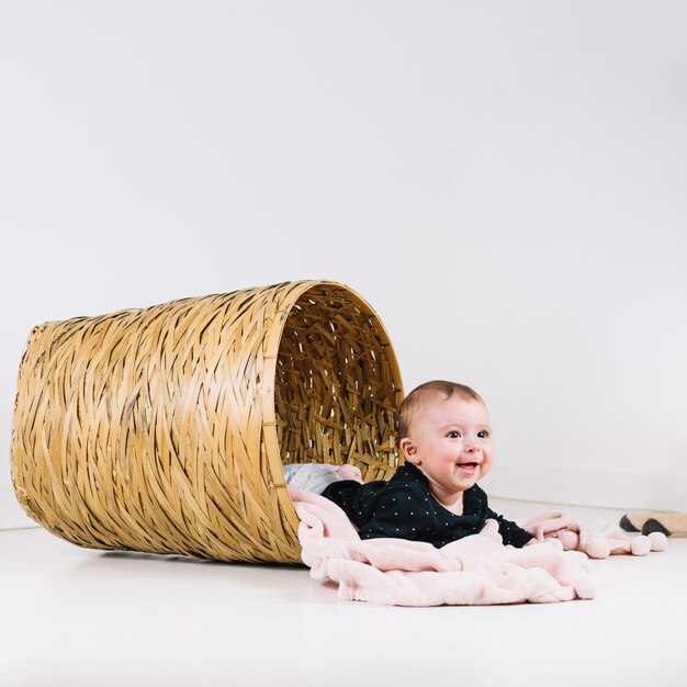 Cheerful baby lying in basket