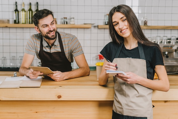 Cheerful bartenders near counter