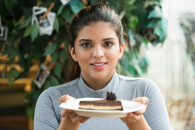 Cheerful beautiful girl has cooked cake