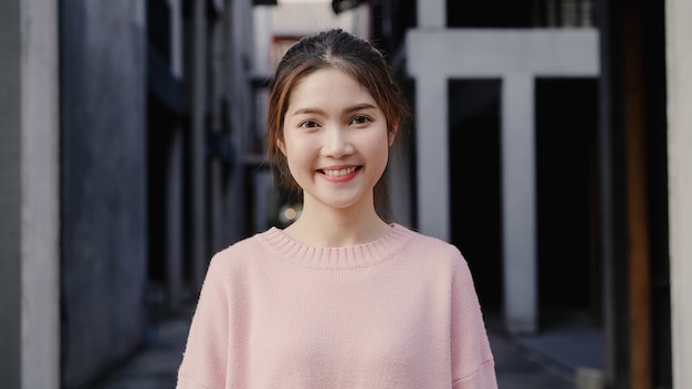 陽気な美しい若いアジア女性、北京のチャイナタウンで旅行中にカメラに笑顔を幸せに感じます。