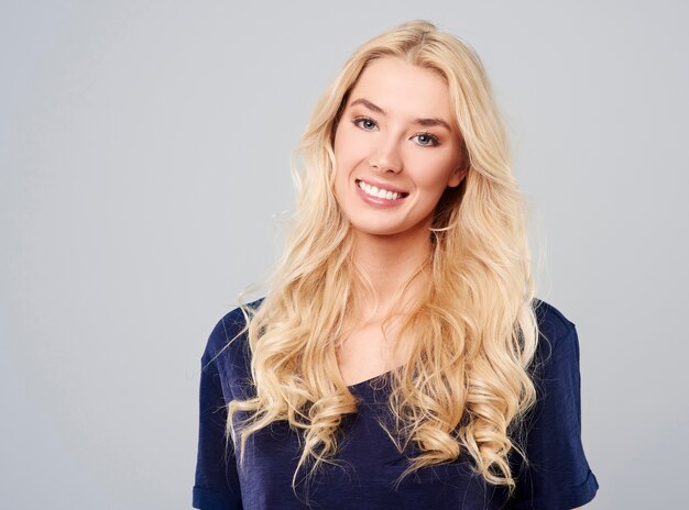 Cheerful blonde girl on gray background