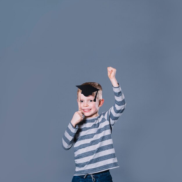 Cheerful boy in academic hat