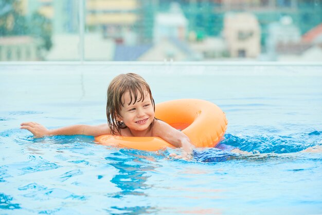 Cheerful boy swimming in pool