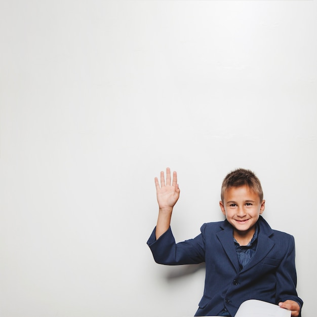 Cheerful boy with hand up