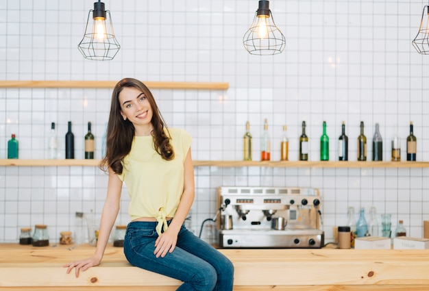 Cheerful brunette on bar counter