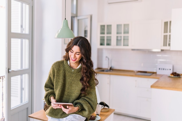 Foto gratuita brunette allegro facendo uso della compressa