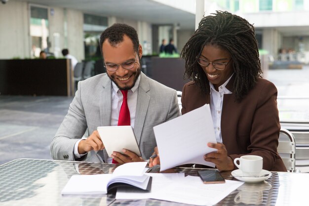 Cheerful business colleagues checking documents
