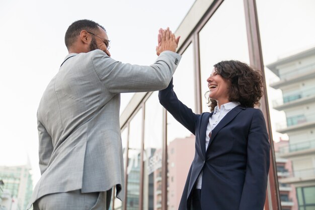 Cheerful business colleagues giving high five