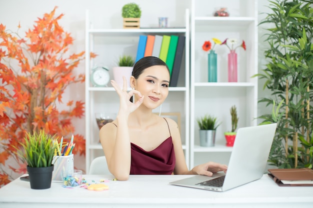 Cheerful business lady working on laptop in office