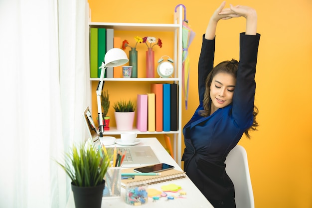 Free photo cheerful business lady working on laptop in office