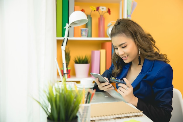 Free photo cheerful business lady working on laptop in office