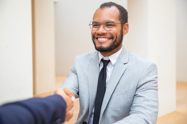Free photo cheerful business man greeting colleague