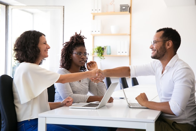 Cheerful business partners shaking hands