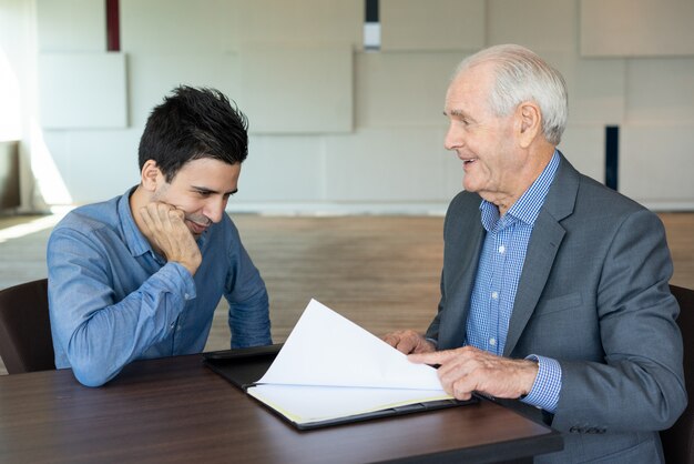 Cheerful business people discussing document