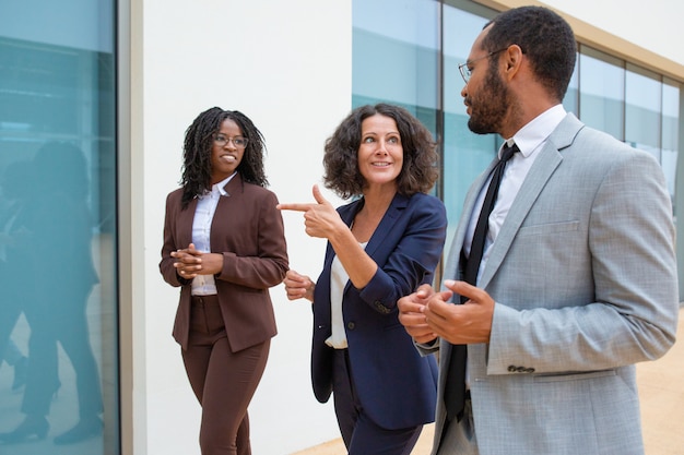 Cheerful business people walking and talking