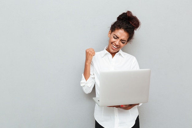 Cheerful business woman make winner gesture.