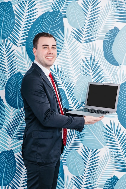 Cheerful businessman holding laptop