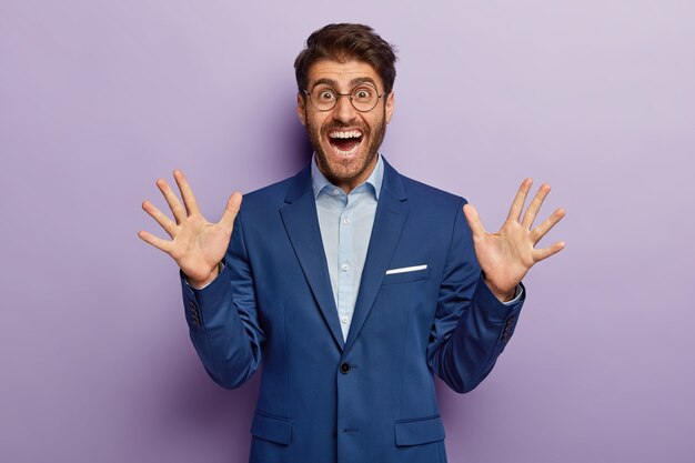 Cheerful businessman posing in classy suit at the office