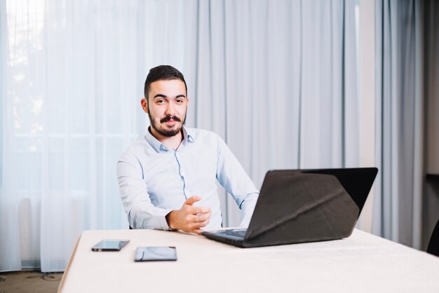 Cheerful businessman posing at table