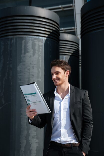 Cheerful businessman reading documents