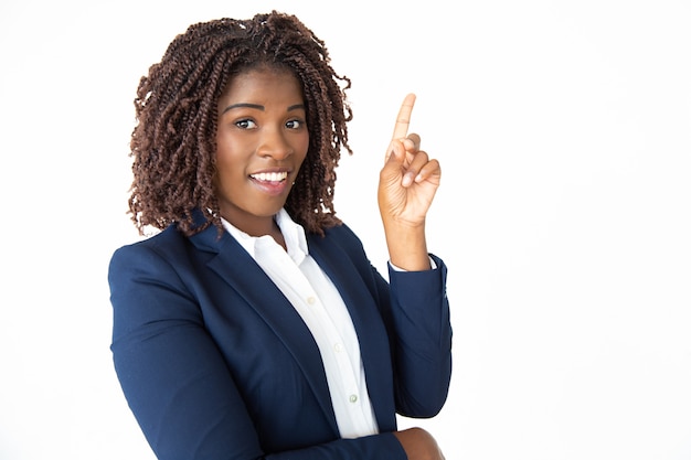 Cheerful businesswoman pointing up