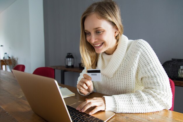 Cheerful businesswoman scanning credit card using web camera