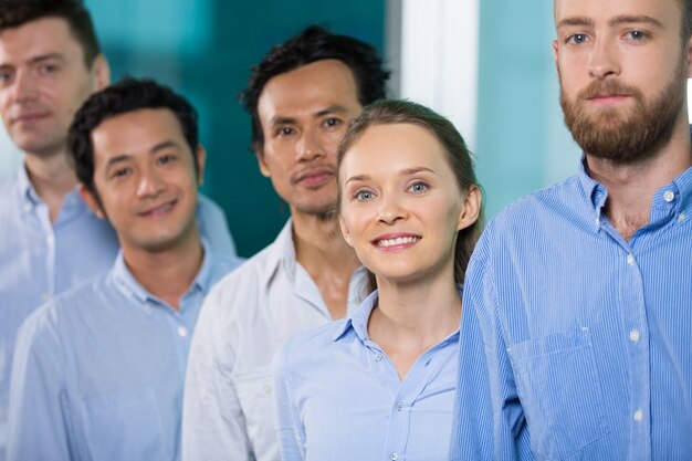 Cheerful businesswoman standing in row