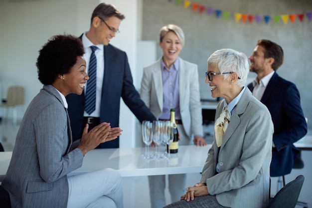 Cheerful businesswomen talking at office party