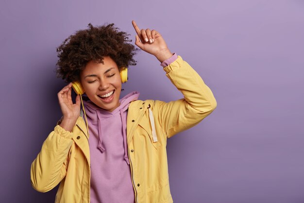 Cheerful carefree woman enjoys music sound in new headphones