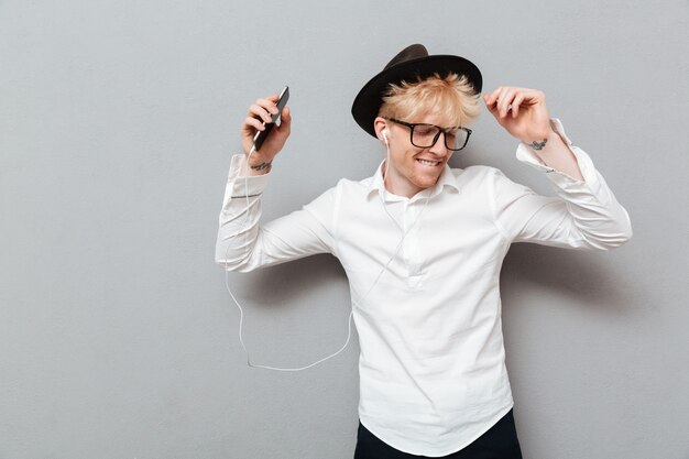 Cheerful caucasian man wearing glasses listening music