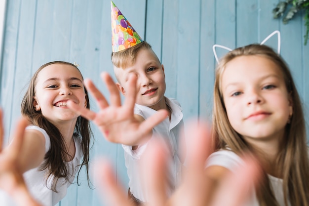 Bambini allegri che provano a raggiungere la macchina fotografica