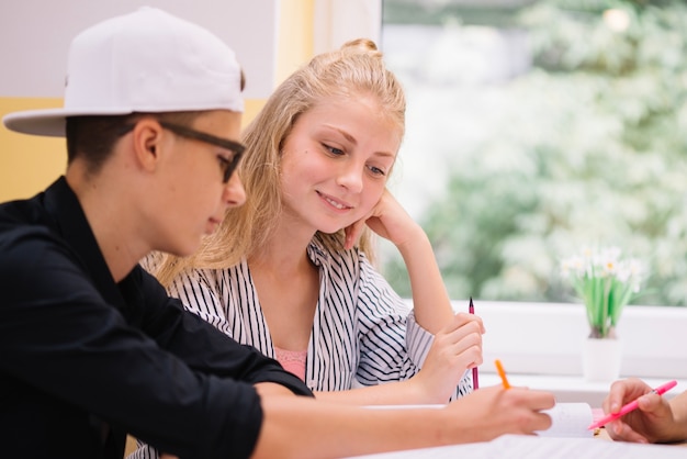 Compagni di classe allegri che studiano insieme