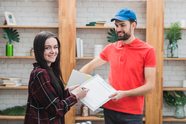 Free photo cheerful client and courier with clipboard