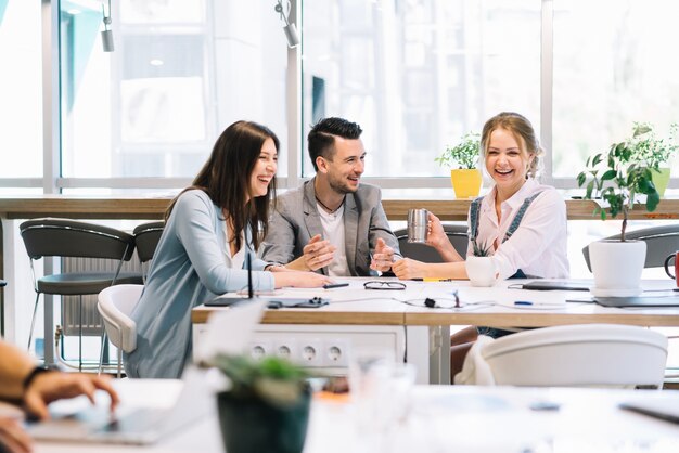 Cheerful colleagues communicating during break