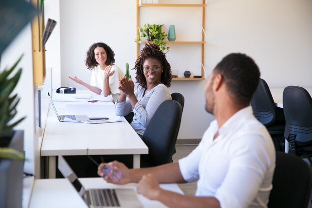 Cheerful colleagues communicating at workplace