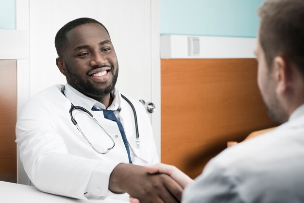 Cheerful colleagues handshaking in hospital