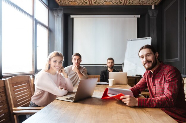 Cheerful colleagues sitting in office